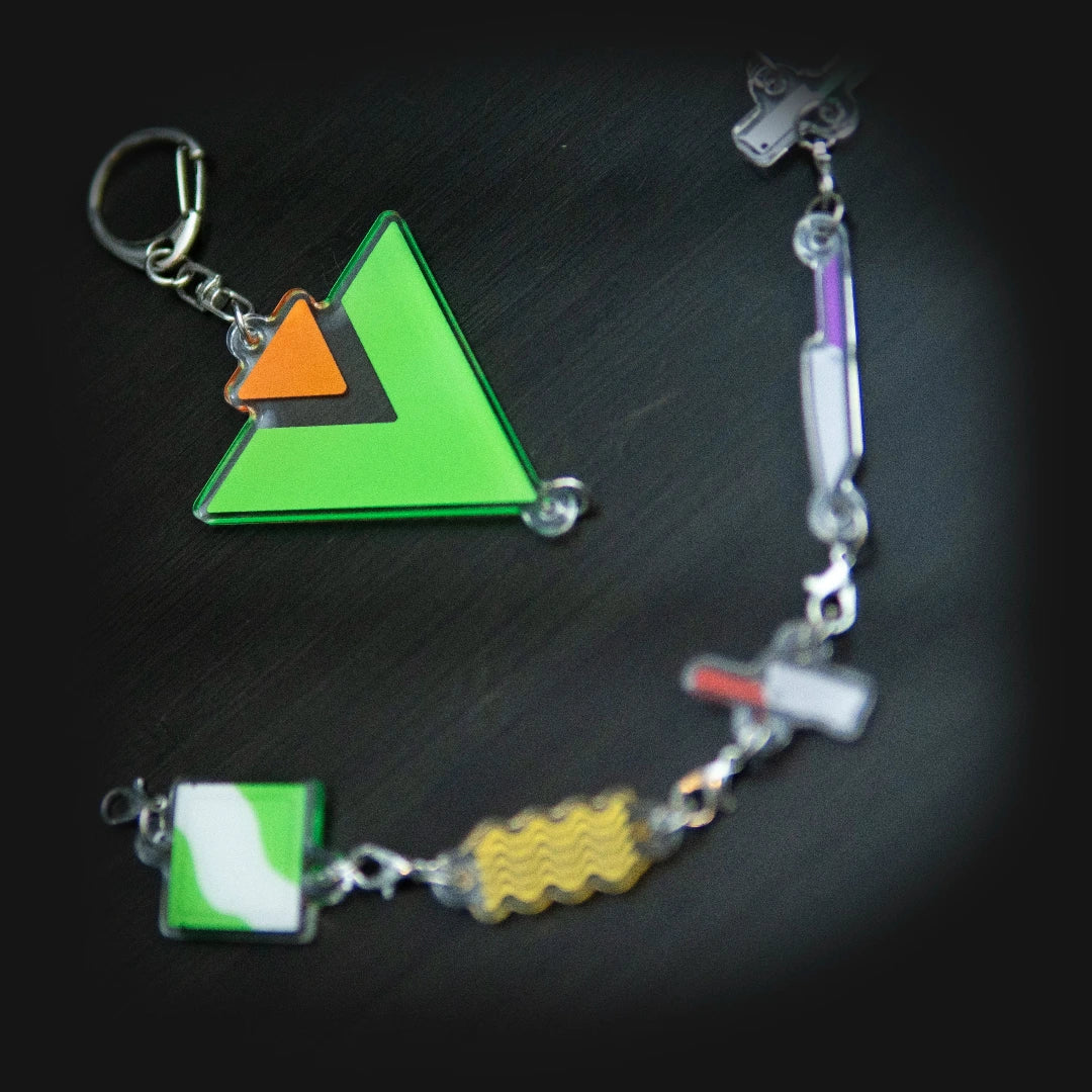 Keychain with colorful triangle and square charms on a dark surface